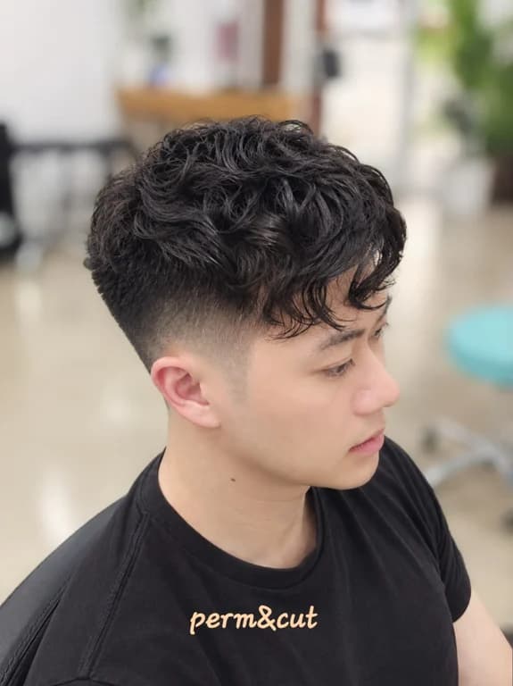 Curly textured haircut with a clean fade and defined curls.